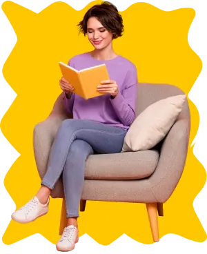 A woman sitting comfortably in a chair, engrossed in reading a book.
